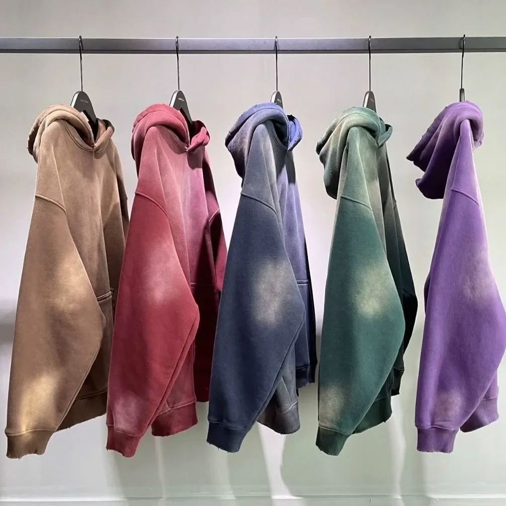 Acid-wash pullover hoodies in five colours on a rail, made in our factory