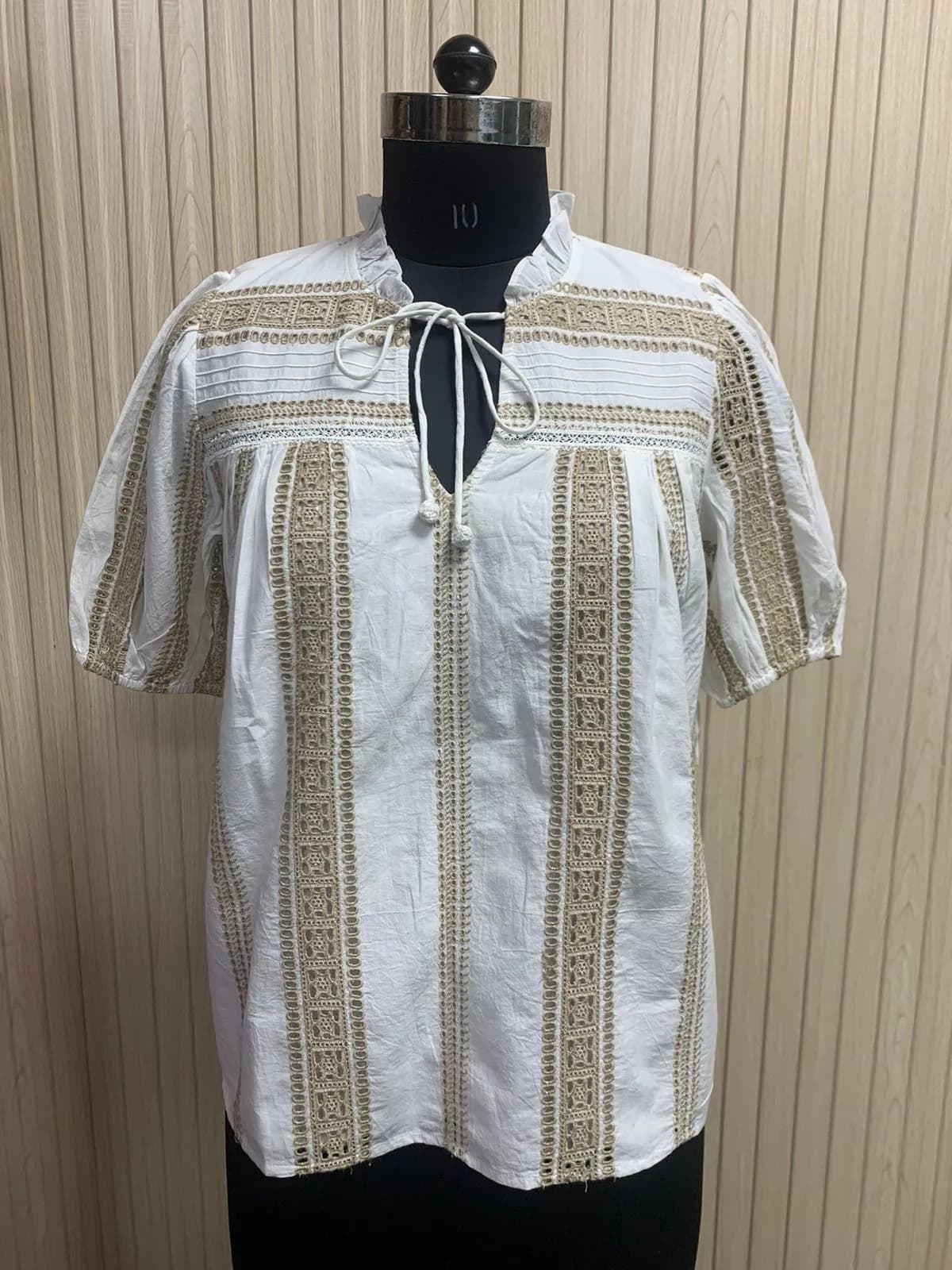 Front view of a white and beige lace-insertion puff-sleeve blouse on a dress form