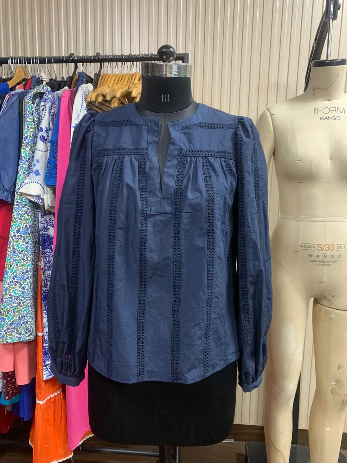 Front view of an indigo ladder-lace yoke blouse on a dress form