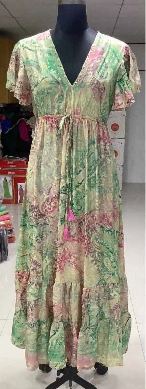 Front view of a green, pink and gold paisley flutter-sleeve maxi kaftan dress on a dress form