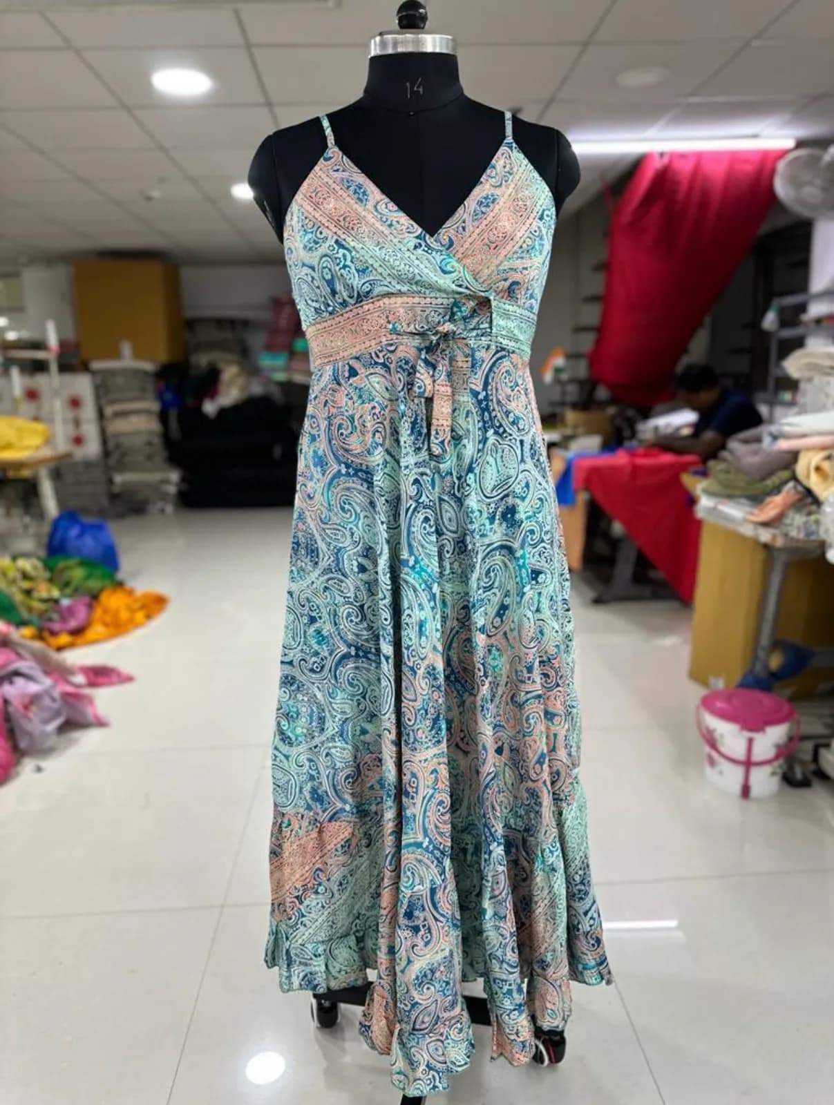Front view of an aqua paisley paisley strappy cut-out maxi dress on a dress form