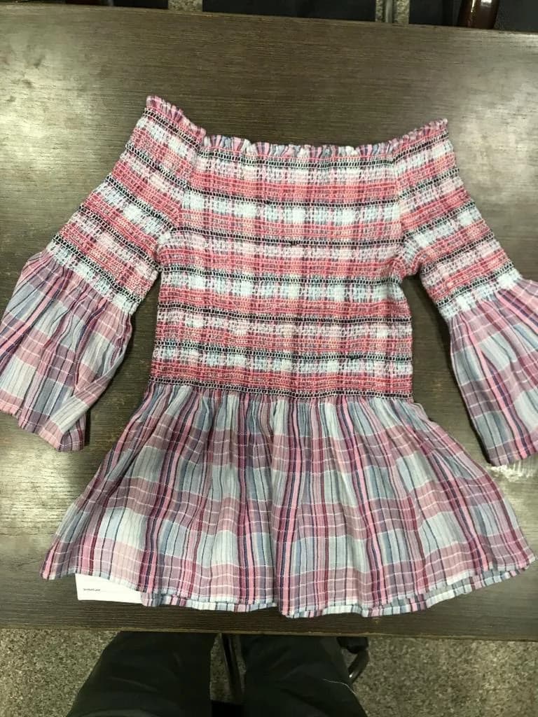 Pink and blue plaid plaid smocked off-shoulder top laid flat