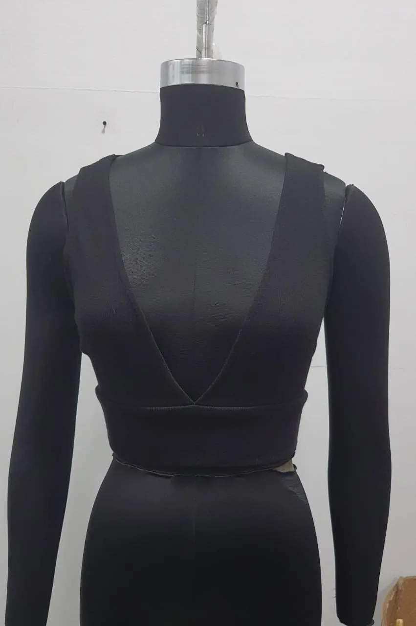 Front view of a black plunge-neck knit crop top with cross back on a dress form