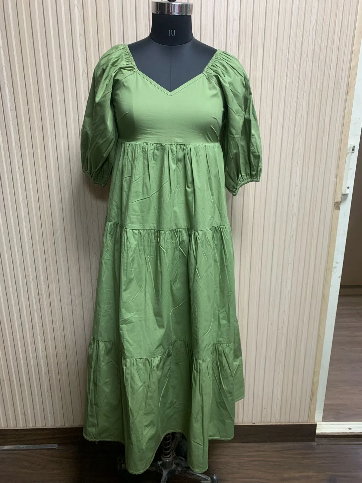 Front view of a sage green puff-sleeve sweetheart tiered maxi dress on a dress form