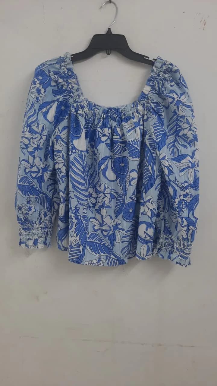 Front view of a blue and white tropical-print off-shoulder blouse on a hanger