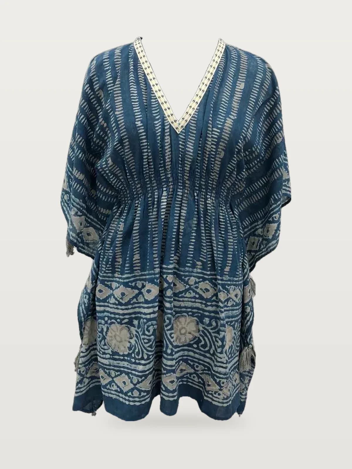 Front view of an indigo batik-print kaftan top with tassels on a dress form
