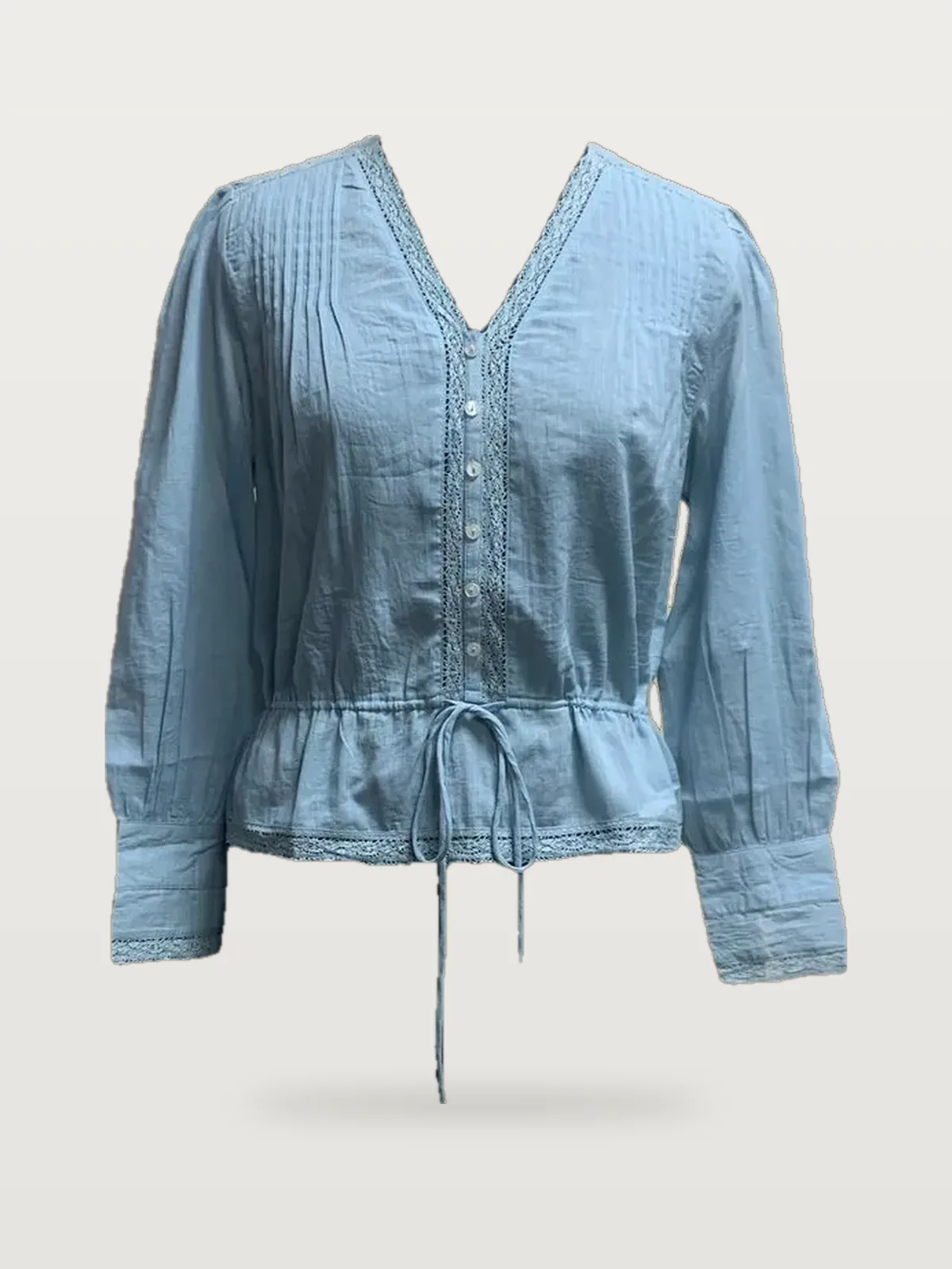 Front view of a light blue chambray drawstring-waist blouse on a dress form