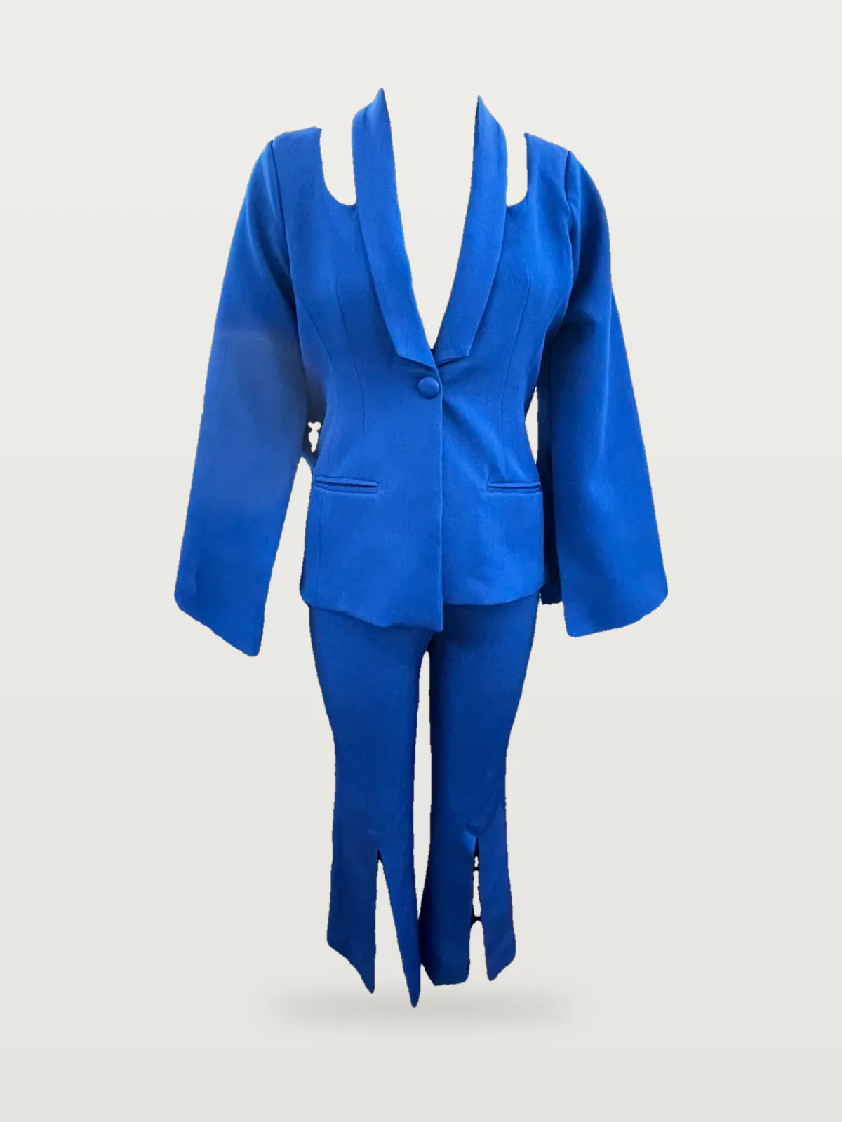 Front view of a royal blue cut-out shoulder blazer suit with split-hem trousers on a dress form