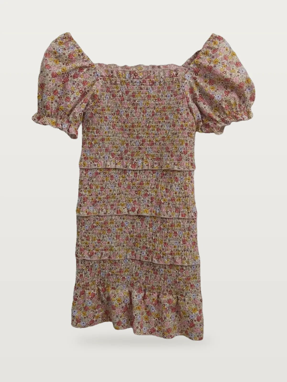 Front view of a pink floral ditsy floral smocked puff-sleeve mini dress on a hanger