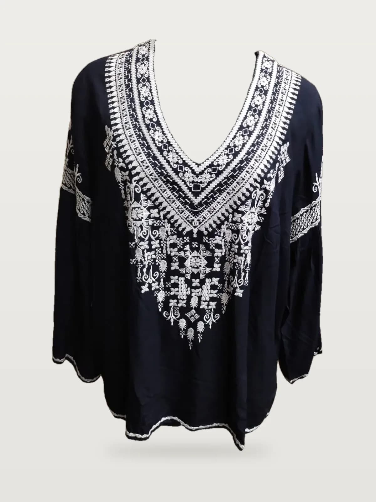 Front view of a navy and white embroidered V-neck tunic top on a dress form