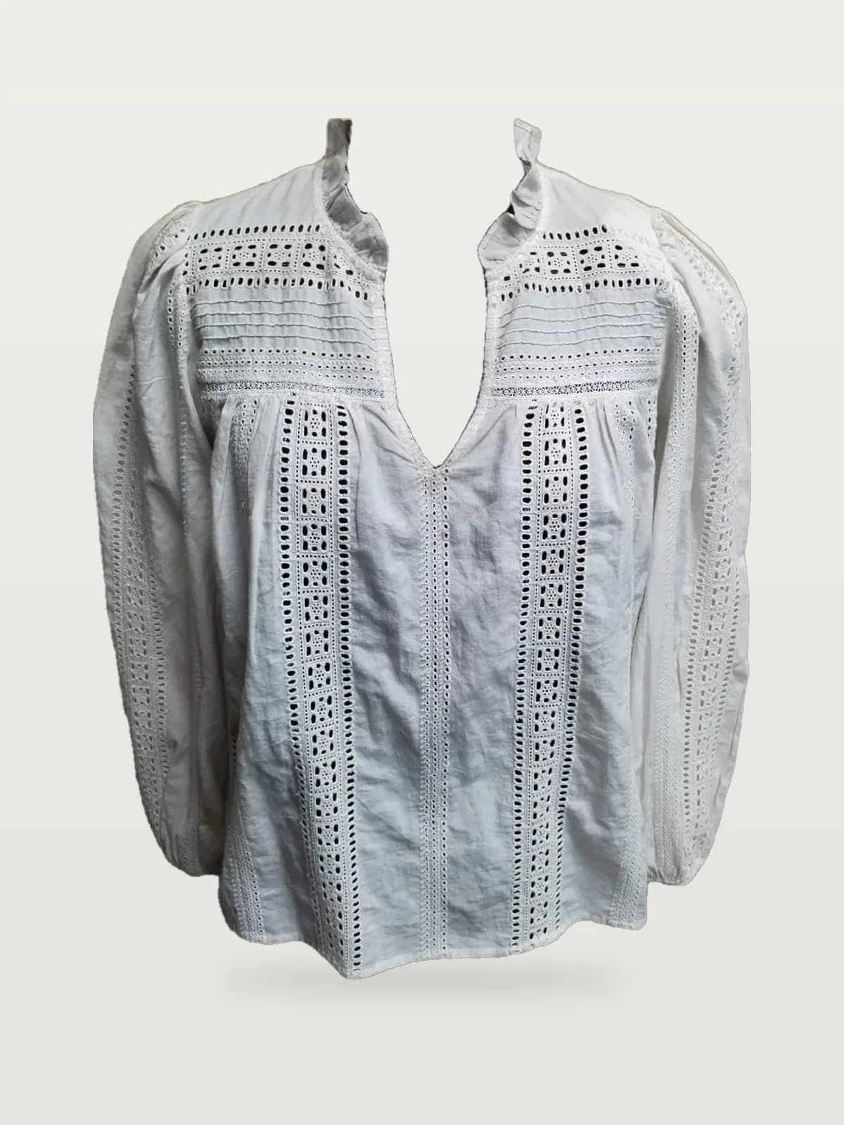 Front view of a white eyelet plunge-neck blouse with ruffle collar on a dress form