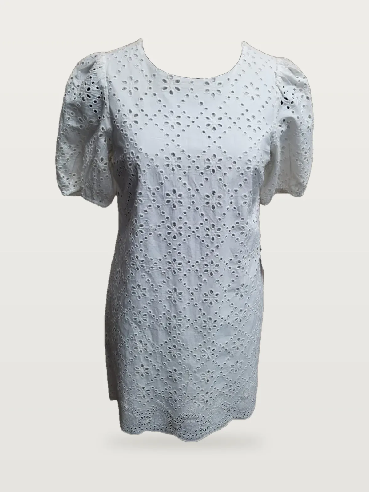 Front view of a white eyelet puff-sleeve shift mini dress on a dress form