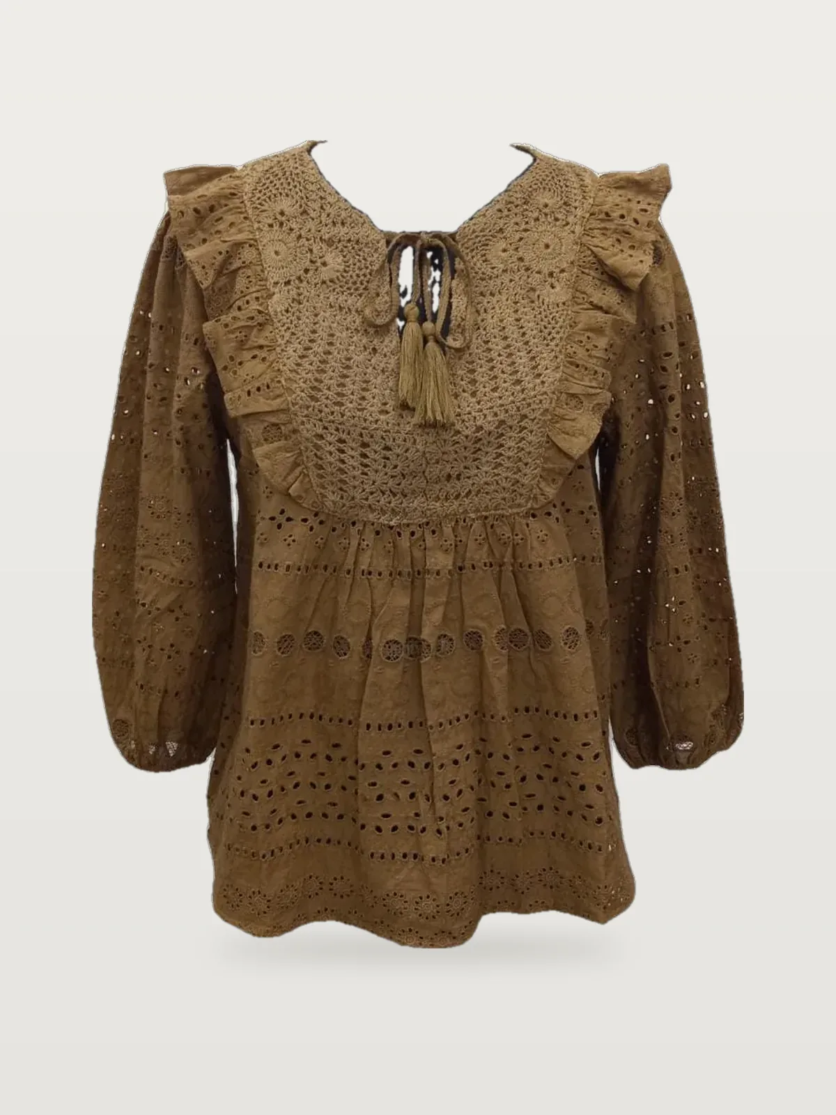 Front view of a tan eyelet ruffle-yoke tie-neck blouse on a dress form