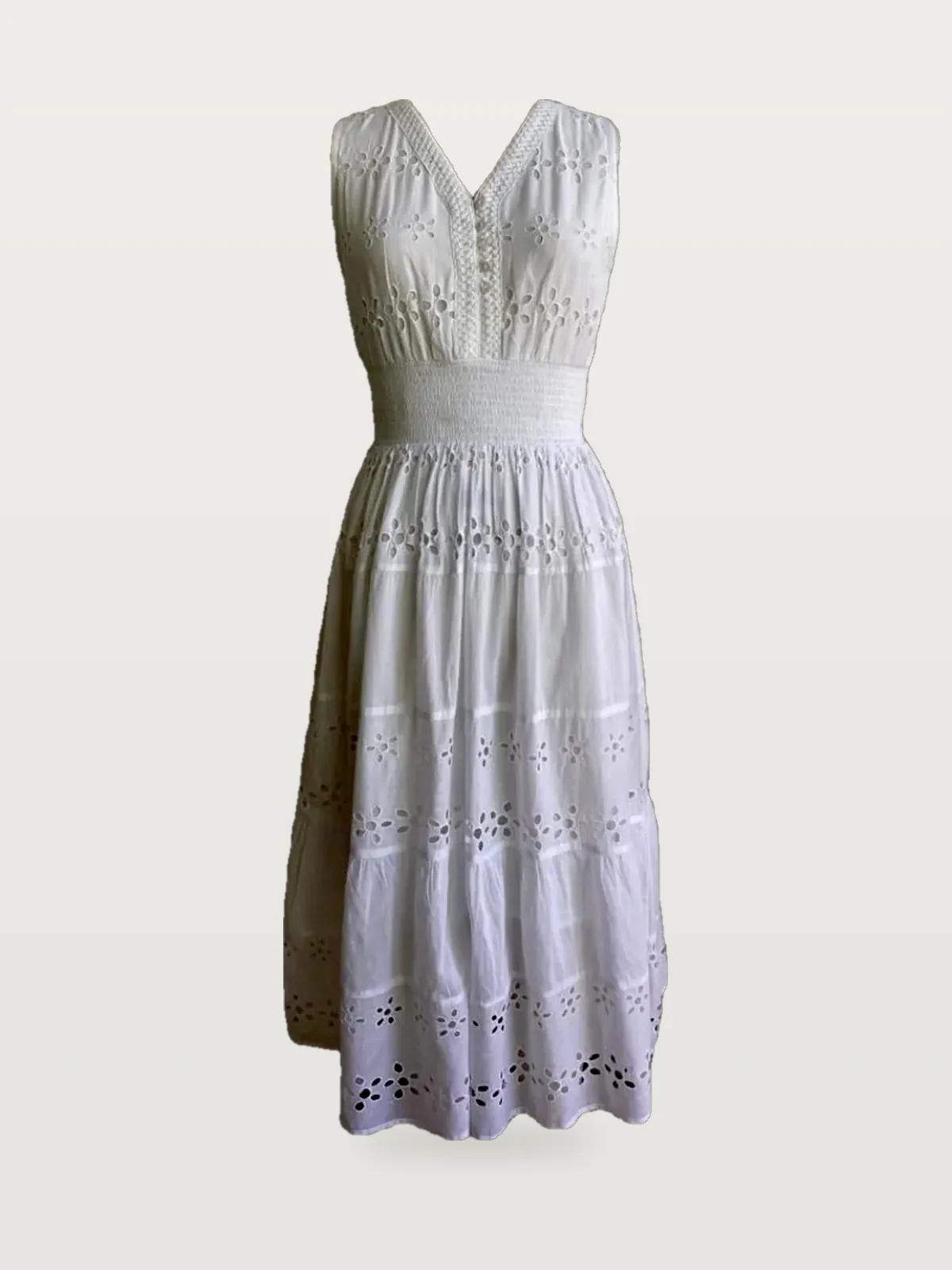 Front view of a white eyelet V-neck tiered midi dress on a dress form