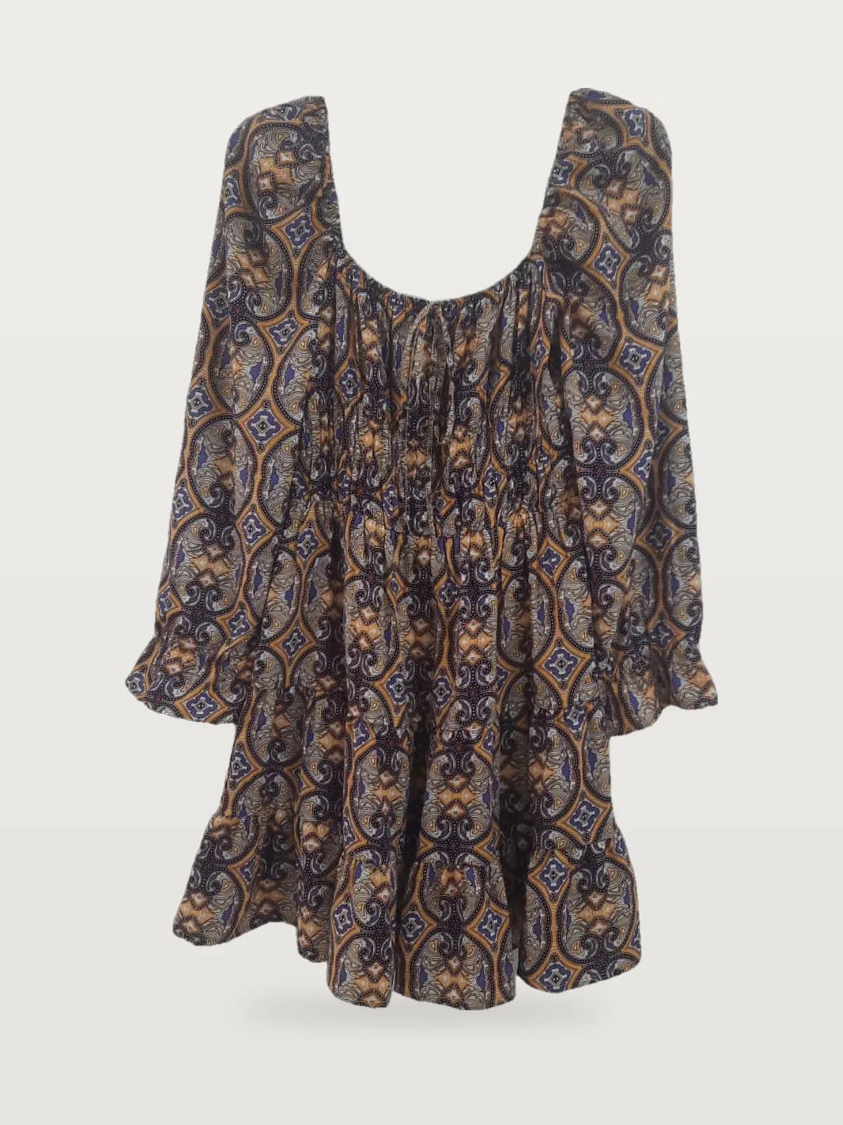 Front view of a purple and mustard medallion-print long-sleeve smocked mini dress on a hanger