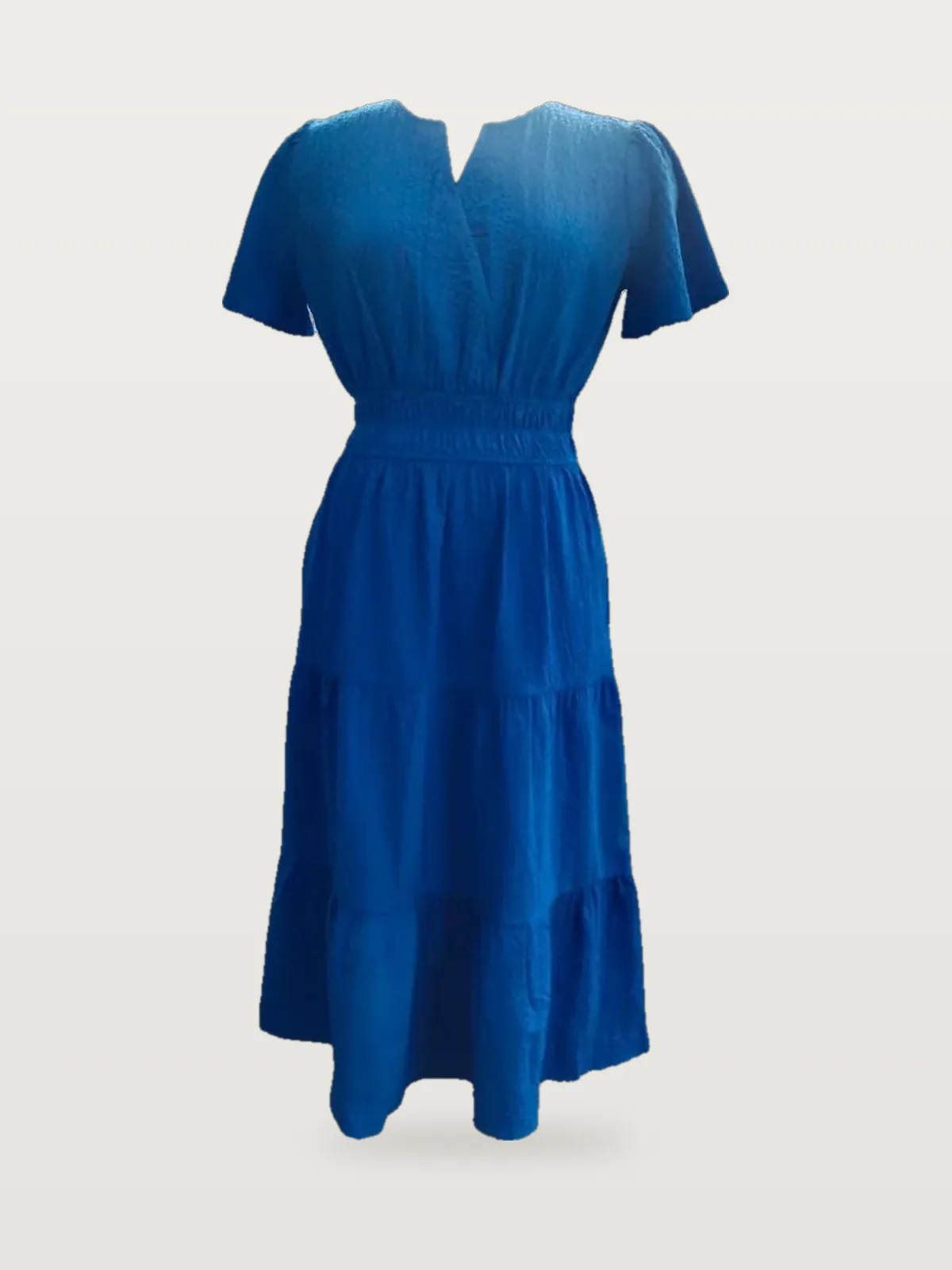Front view of a cobalt blue notch-neck smocked-waist tiered midi dress on a dress form