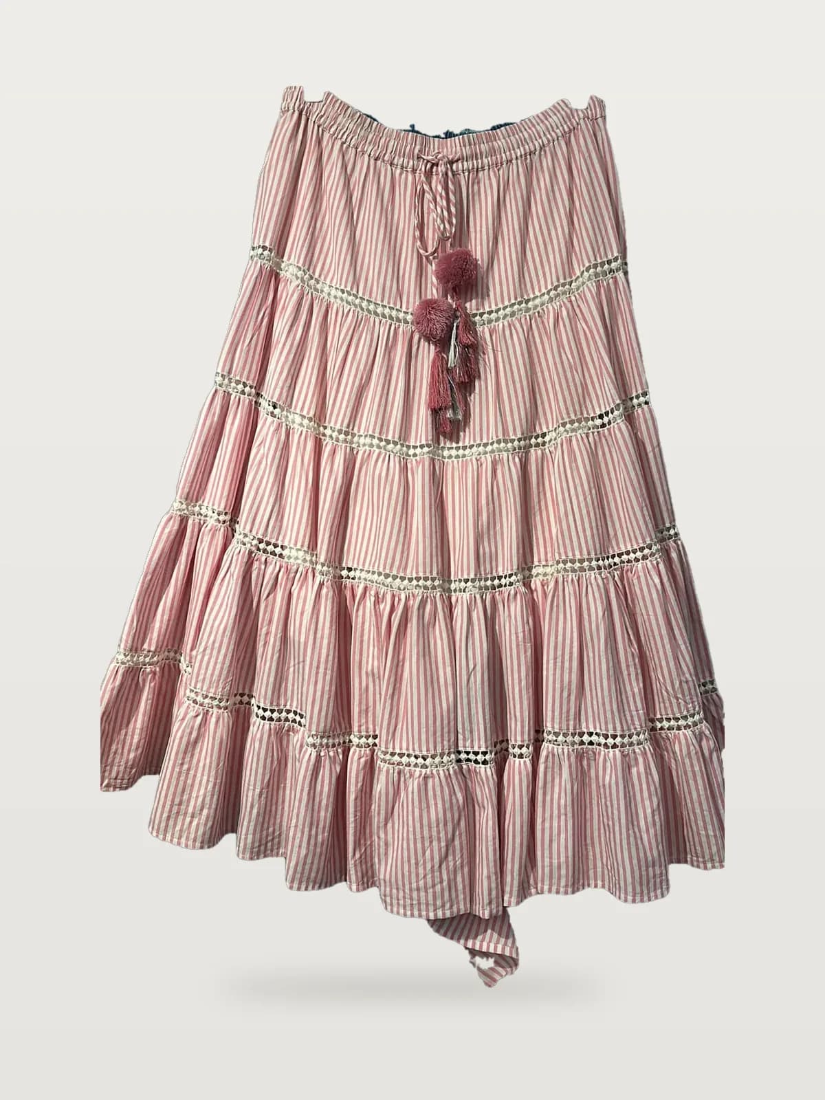 Front view of a pink stripe striped tiered maxi skirt with lace and pompoms on a hanger