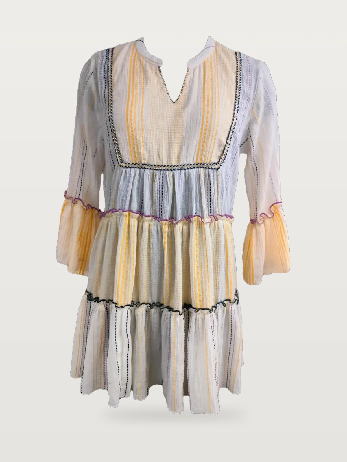 Front view of a cream and yellow striped tiered tunic dress with embroidered bib on a dress form