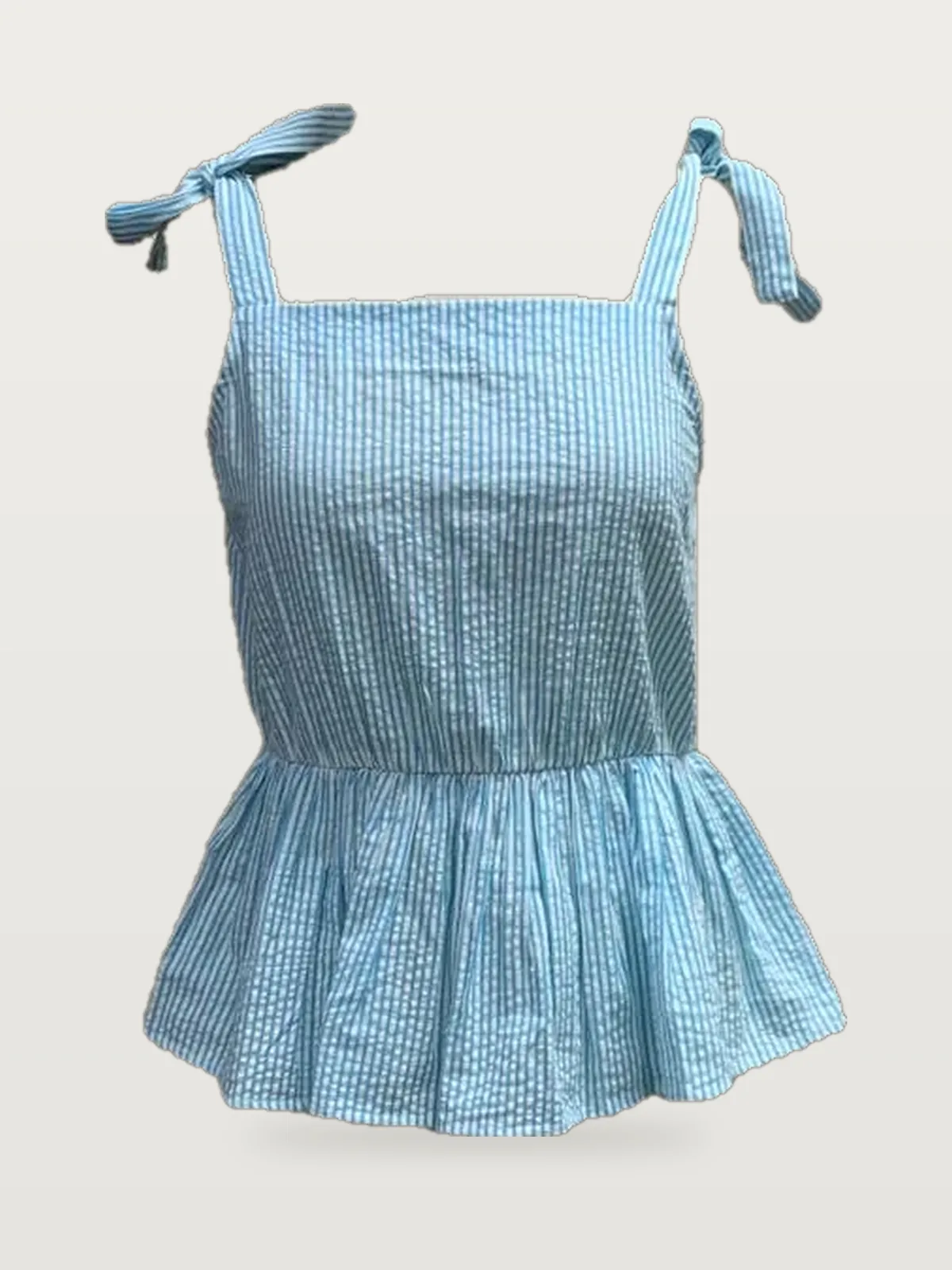 Front view of a light blue tie-shoulder seersucker peplum top on a dress form