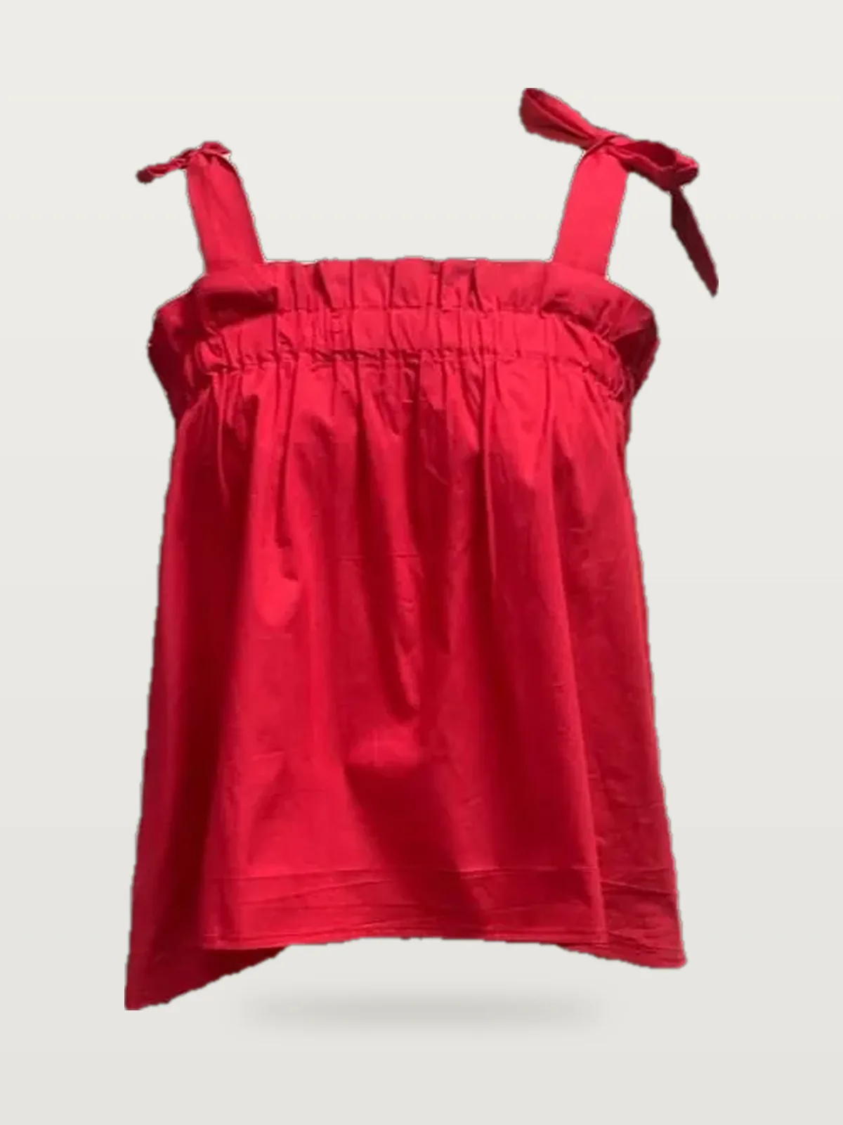 Front view of a red tie-strap ruffle-neck cami top on a dress form