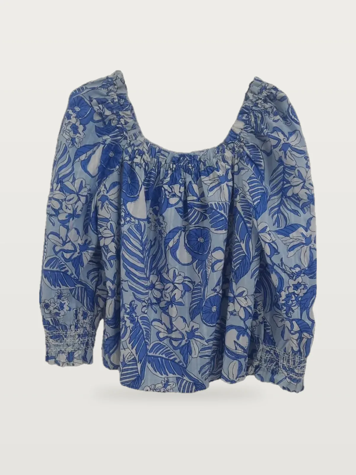 Front view of a blue and white tropical-print off-shoulder blouse on a hanger