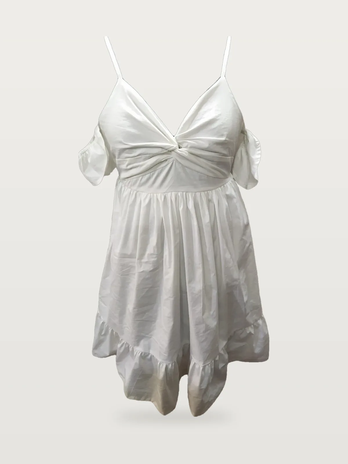 Front view of a white twist-front cold-shoulder mini dress on a dress form