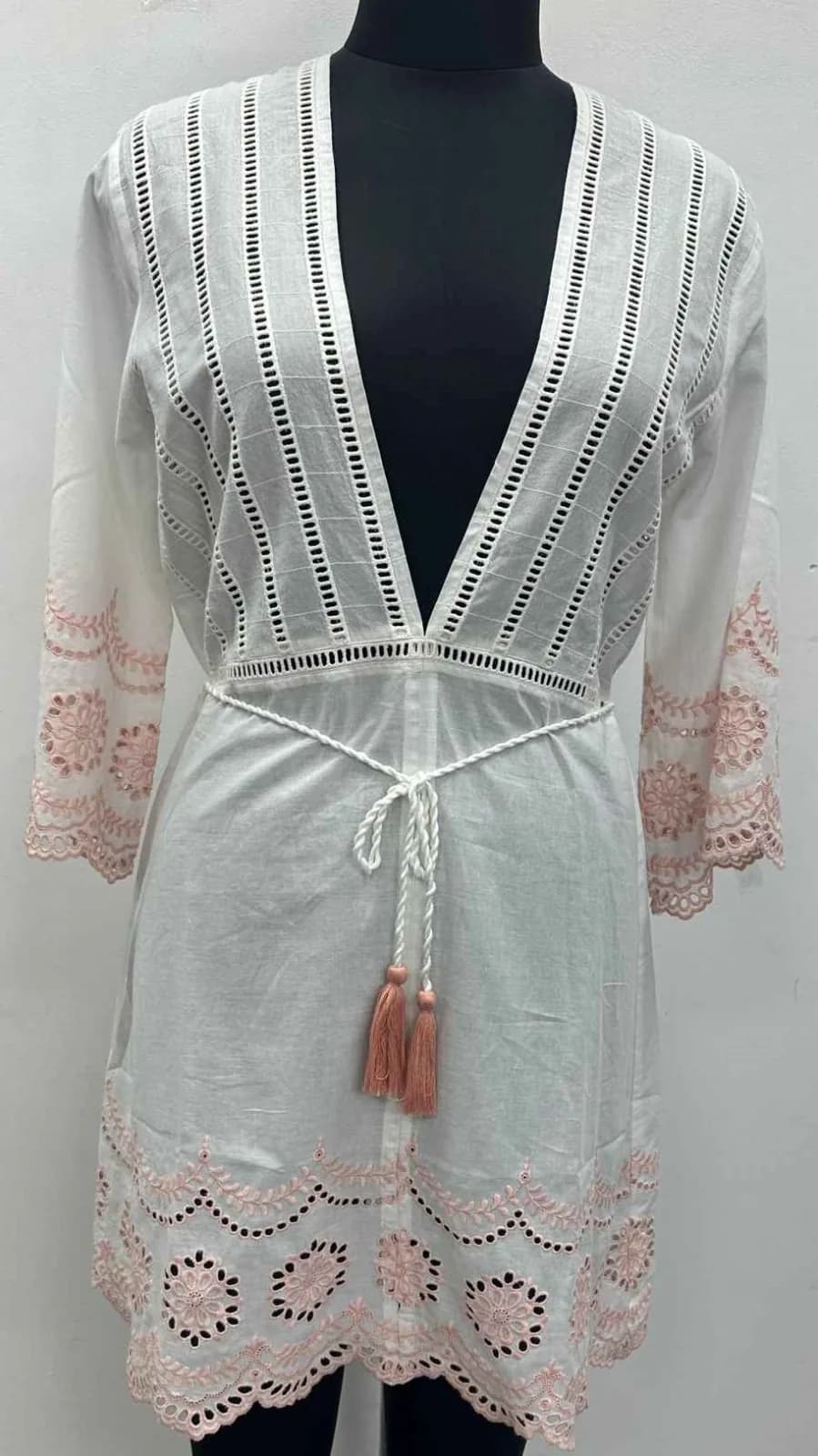 Front view of a white and pink eyelet plunge-neck tunic cover-up on a dress form