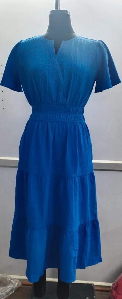 Front view of a cobalt blue notch-neck smocked-waist tiered midi dress on a dress form