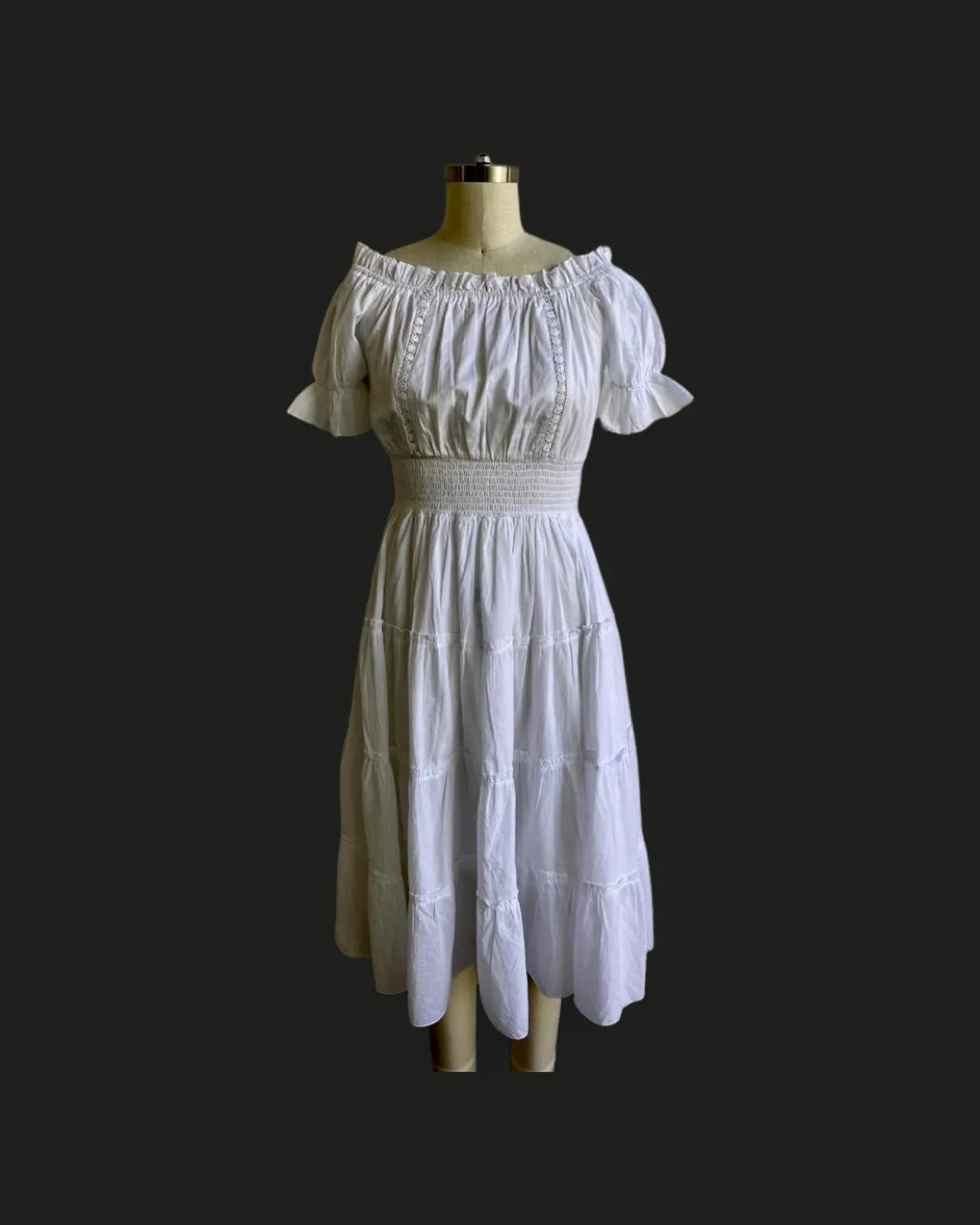 Front view of a white off-shoulder tiered midi dress with lace insertion on a dress form