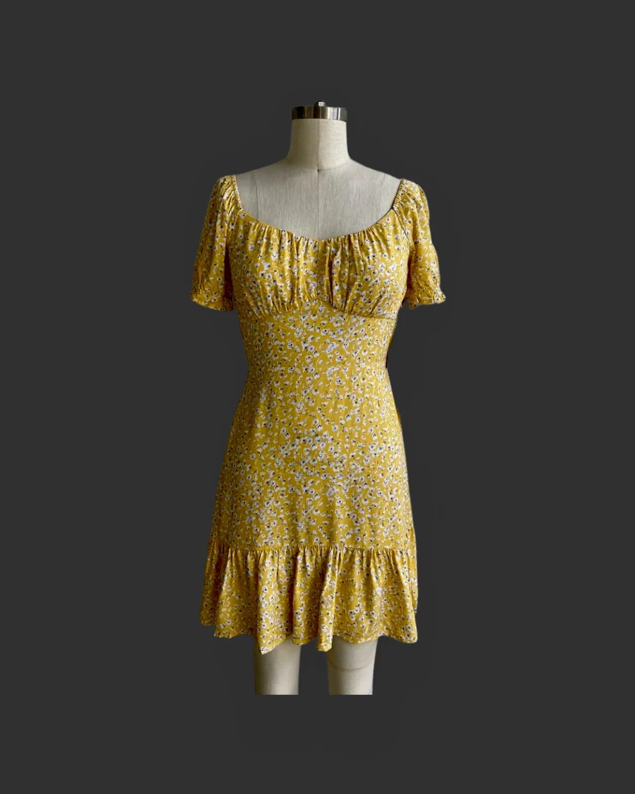 Front view of a yellow floral puff-sleeve ditsy floral mini dress on a dress form